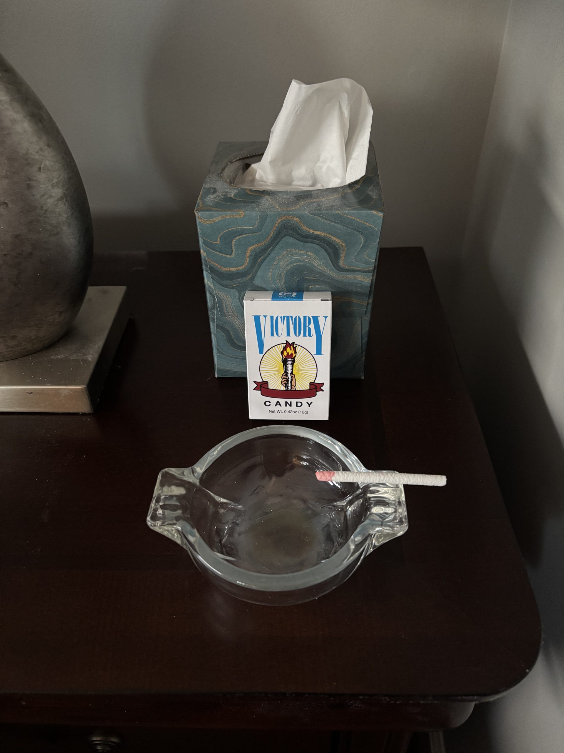 Bob's glass ashtray with one of those old-fashioned candy cigarettes sitting in it with the box next to it